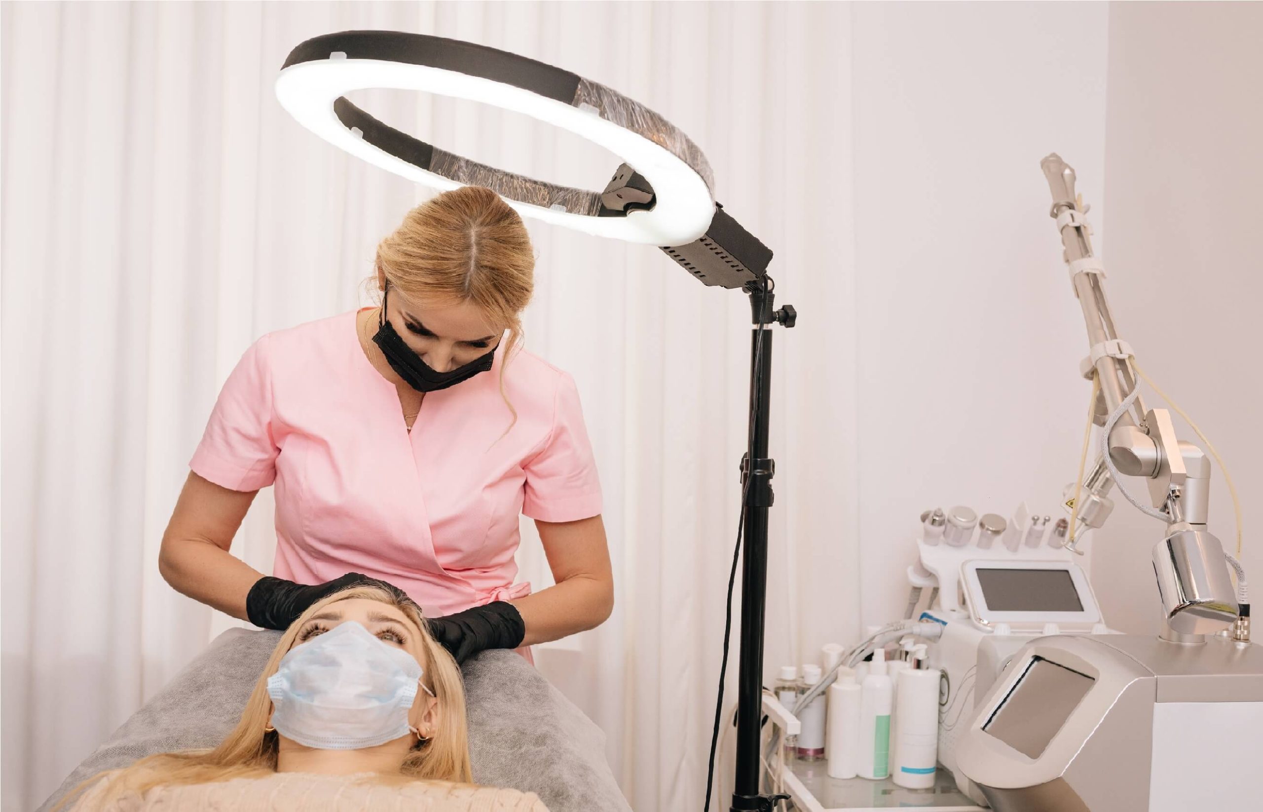 A female doctor before starting a hair transplant procedure on a female patient.